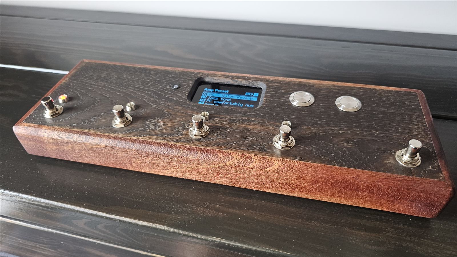 Il pedale finito: scatola di legno, cinque footswitch, display al centro e due tasti banco a destra